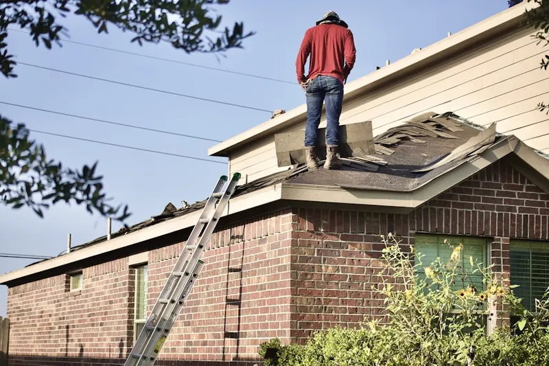 Professional roofer working on a residential roof in Owatonna